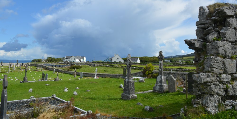 Beyond the ruined church is the  village of Fanore scenic drive R477 road from Doolin to Ballyvaughan via Fanore, The Burren, Murrooghtoohy, Co. Clare, Ireland